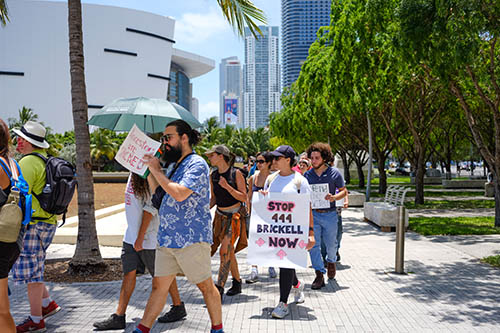 People marching with the sign Stop 444 Brickell Now