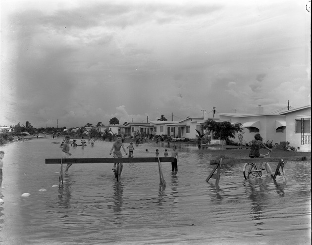 Children play in a flooded street in North Miami