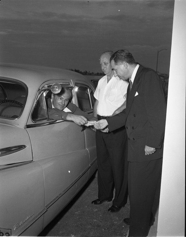 Driver in car paying toll booth at Broad Causeway Bridge during at the opening ceremony