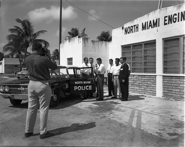 North Miami Police Department employee testing new radio system to communicate with dispatchers in front of City authorities
