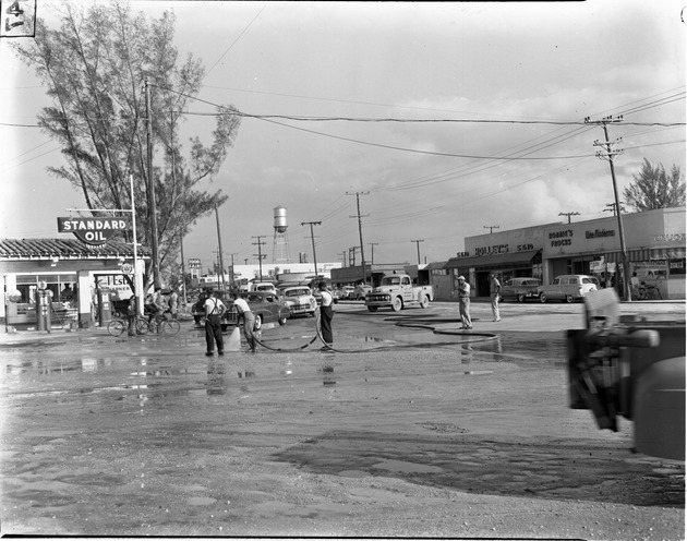Workmen washing down 125th Street by Standard Oil dealer area in North Miami