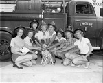 Young girls pose with a Dalmatian dog by fire engine no.1 at the North Miami Fire Dept. no.1