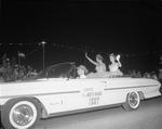 Junior Miss North Miami 1960-1961 waves at crowds while riding in a car during Festival of Progress parade