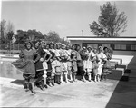 Swim and Slim Club women wearing Victorian bathing suits costumes pose line-up for a picture at the North Miami public pool