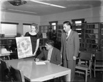 [1958-03-04] Mayor Sasso looking at a National Library Week poster at the North Miami Public Library