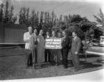[1961-01-23] City officials holding a sign City of Progress Welcomes You