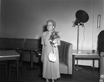 Lady posing with flowers at the 1952 Optimist Club gala