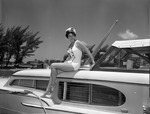 Young lady wearing a sea captain's cap sitting on a boat