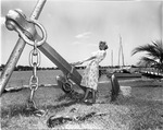 [1959-06-08] Young lady posing by a large sculpture of an anchor
