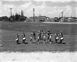 [1958-07-31] Baton twirling majorettes and drum Corps pose with Bob Rose on a school field