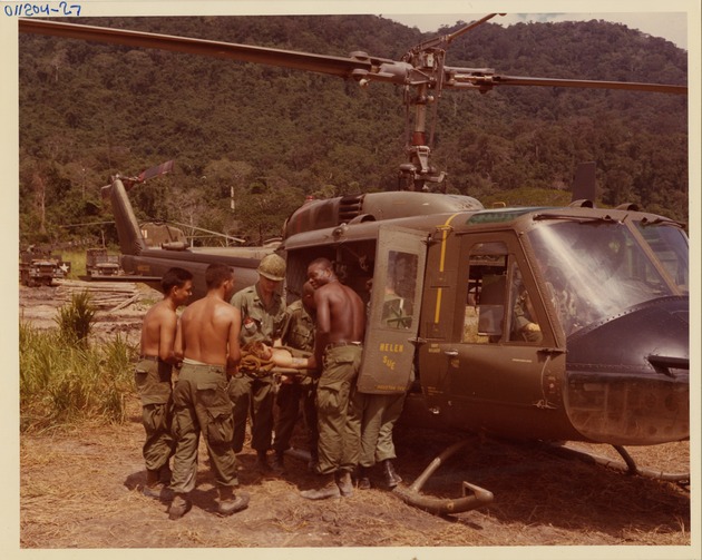 Stretcher Bearers Loading Casualty into US Army MEDEVAC UH-1 Helicopter "Helen Sue". - 