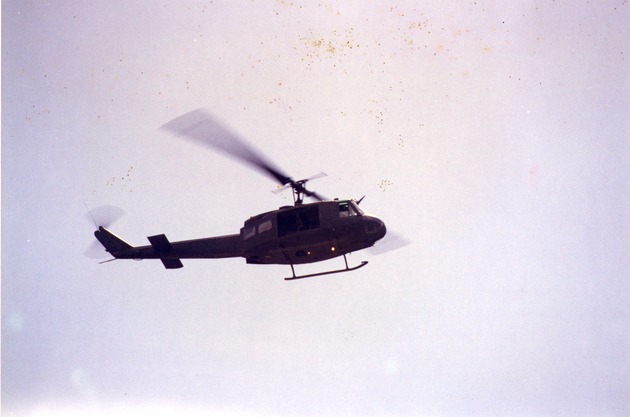 Dark-colored helicopter in flight - 