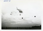 Helicopter flies while carrying barrels