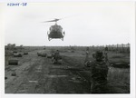 Crew member guides landing helicopter