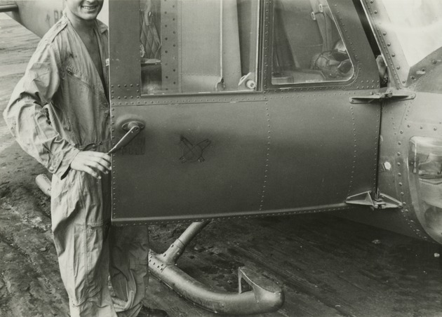 RAAF Squadron 9 member stands by helicopter door - 