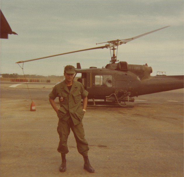 Soldier poses in front of UH-1B - 