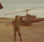 Soldier poses in front of UH-1B