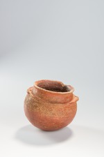 Small irregular reddish ceramic bowl with crude incised and punctate designs