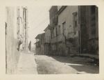 Two men standing on a paved city street, Santiago de Cuba after 1932 earthquake