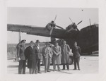 Abril Lamarque (pictured center) and 6 unidentified men standing in front of car and airplane