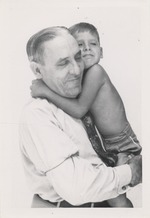 Unidentified man carrying a young boy