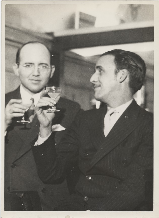 Abril Lamarque (pictured right) holding a cocktail glass  with unidentified man wearing glasses - Recto
