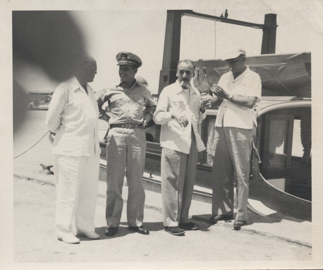 Abril Lamarque (pictured third from left) standing with three unidentified men in front of a boat - Recto