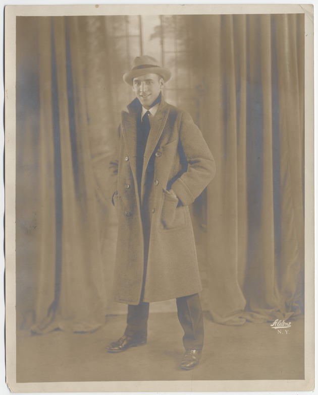 Abril Lamarque in overcoat and hat in front of curtain - Recto