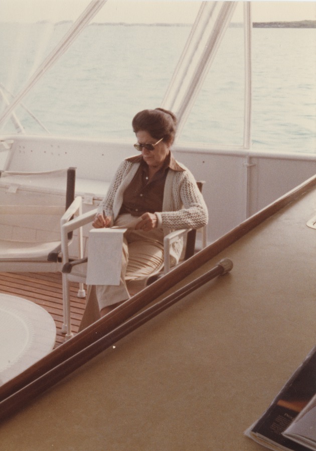 Milagros Lamarque sitting in a chair on the deck of a boat - Recto