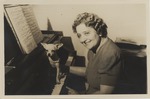 Portrait of Mana-Zucca seated at a piano with a chihuahua