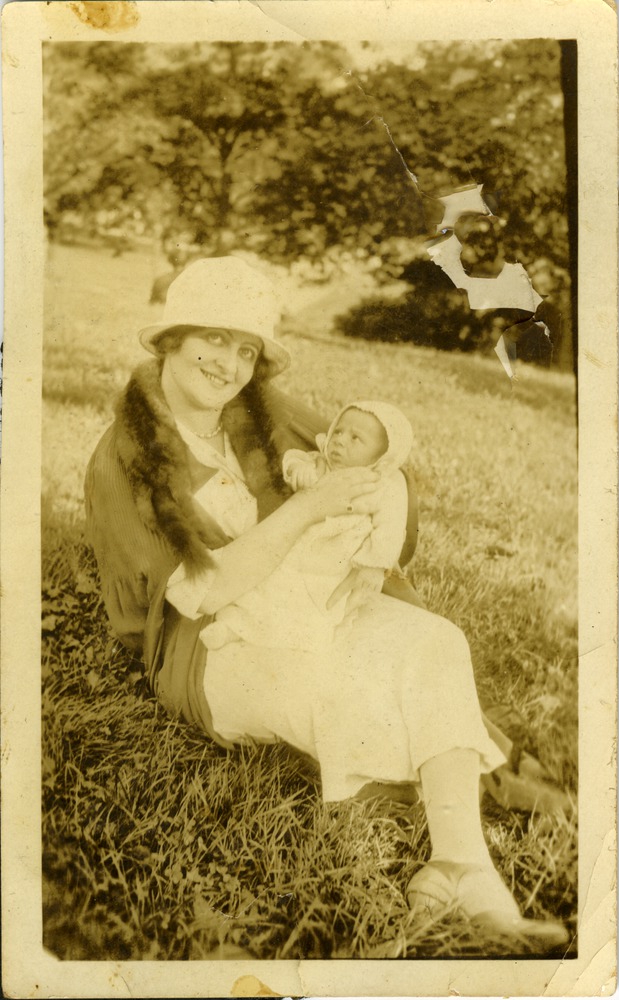 Mana-Zucca carrying a baby Marwin Cassel sitting in the grass - 