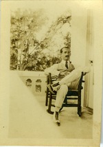 Irwin Cassel  seated in a rocking chair outside