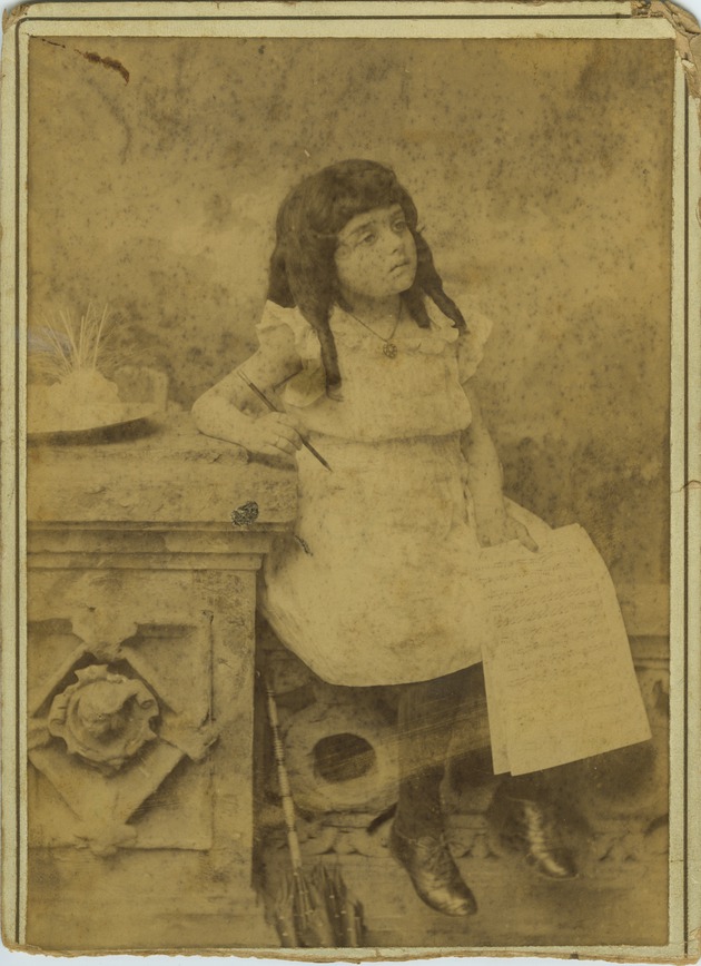 Mana-Zucca age four seated and holding sheet music and a pen - 