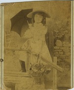 Mana-Zucca age four holding an umbrella and basket of flowers