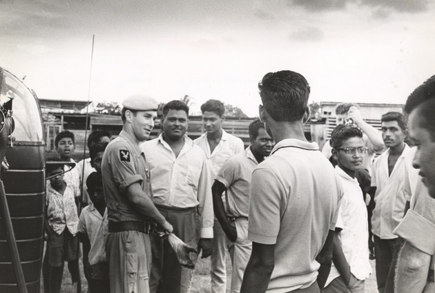 British military member standing among crowd of Guyanese men - 