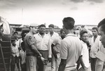 British military member standing among crowd of Guyanese men