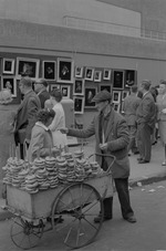 [1960-05-29] A man selling pretzels from a cart in Greenwich Village