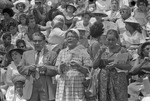 [1960-06-17] Three people holding rosary beads in the stands at Downing Stadium, San Juan Fiesta