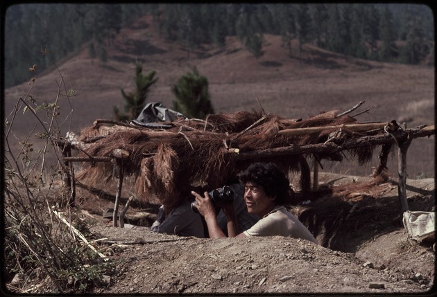 A man with binoculars in a bunker