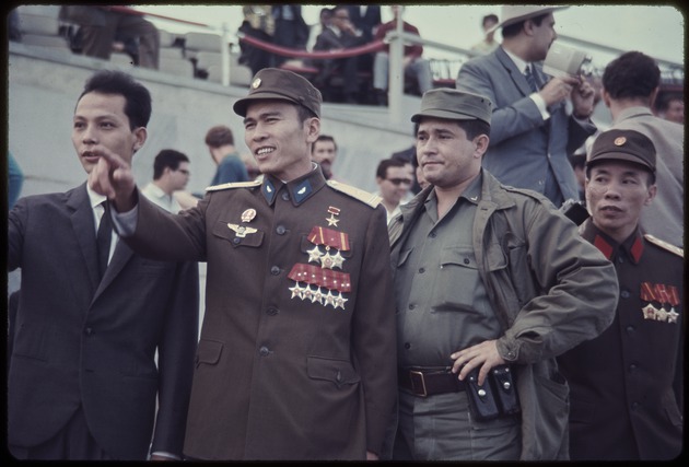 Two North Vietnamese army officers standing with a soldier and man dressed in suit