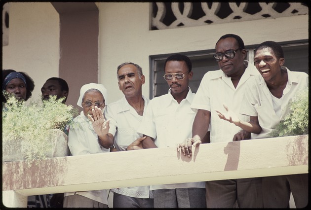 Jean Bertrand Aristide on a balcony with a group of men and women