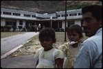 A man and two girls in front of a building