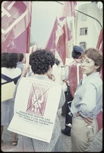 Two women holding flags and signs supporting the Partido Revolucionario de los Trabajadores
