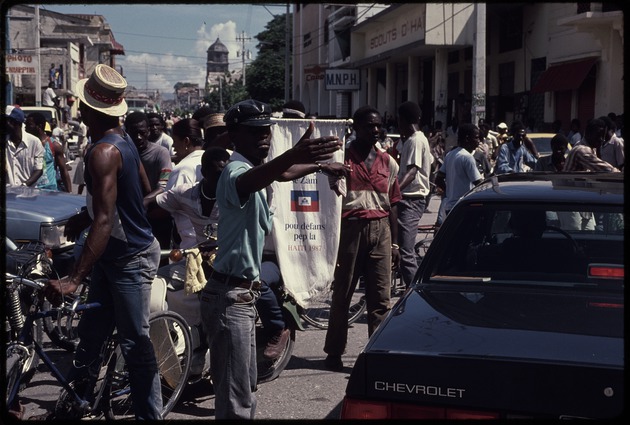 Men in the street on bicycles and carrying signs