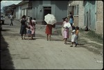 A group of woman and children walking down the street