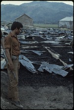 One armed man standing in an area covered in sheet metal