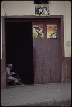 A woman reading the newspaper in a doorway