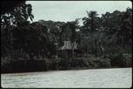 Wooden house with thatch roof on the river