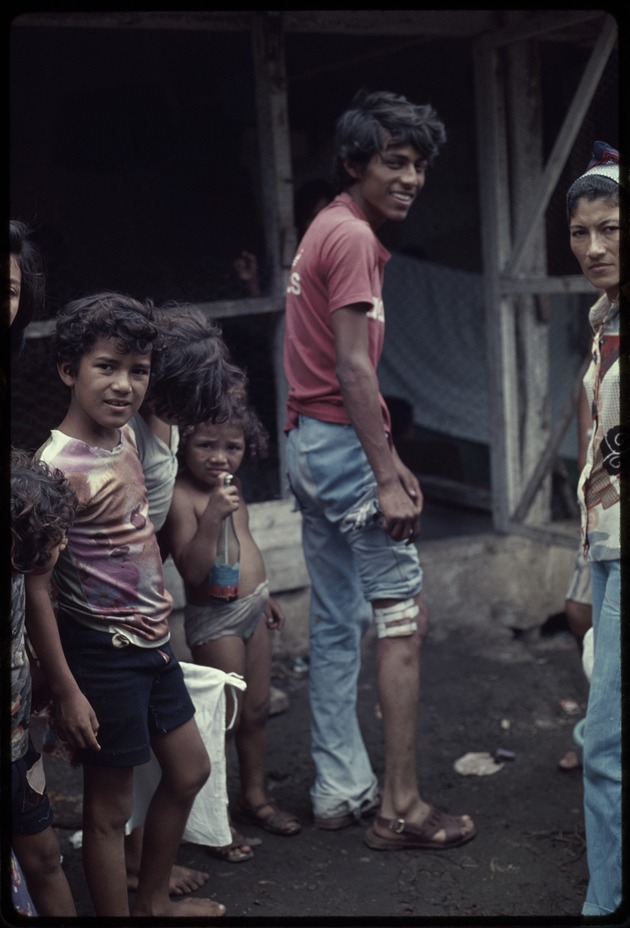 Young man with injured leg standing with a group of children