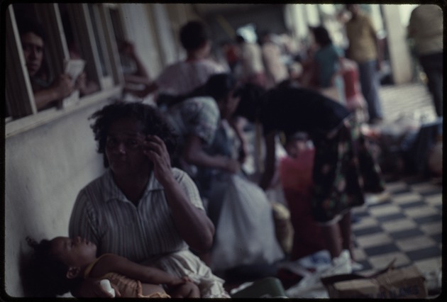 Woman cradling a child sitting outdoors